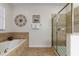Bathroom with a soaking tub, glass shower, tile floors, and decorative artwork and fixtures at 1454 Myrtlewood St, Davenport, FL 33896
