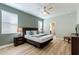 A bedroom featuring a king-size bed, modern decor, wood-look floors, and access to the en suite bathroom at 1454 Myrtlewood St, Davenport, FL 33896