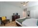 Neutral-toned bedroom features a queen-size bed, dresser, ceiling fan, and wood-look floors at 1454 Myrtlewood St, Davenport, FL 33896