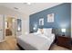 Bedroom featuring a blue accent wall, queen-sized bed, and access to a full bathroom at 1454 Myrtlewood St, Davenport, FL 33896