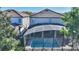An overhead shot of a screen-enclosed pool highlighting the tiled patio and surrounding landscape at 1454 Myrtlewood St, Davenport, FL 33896