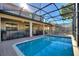 A beautiful pool and patio with ample seating, landscaping, and a covered space for outdoor dining and relaxation at 1454 Myrtlewood St, Davenport, FL 33896