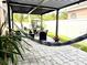 Covered patio area featuring pavers, a stylish hammock, and inviting outdoor seating, perfect for relaxation at 14945 Huntcliff Park Way, Orlando, FL 32824