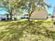 Large backyard features lush green grass, mature trees, and a cozy outdoor seating area at 14945 Huntcliff Park Way, Orlando, FL 32824