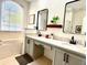Elegant bathroom featuring dual sinks with quartz countertops and modern black fixtures, plus a soaking tub at 14945 Huntcliff Park Way, Orlando, FL 32824