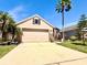 Charming home with lush landscaping, a two-car garage, and a well-maintained front yard at 14945 Huntcliff Park Way, Orlando, FL 32824