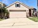 Home featuring a two-car garage, lovely landscaping, and inviting curb appeal at 14945 Huntcliff Park Way, Orlando, FL 32824
