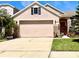 Charming single-Gathering home featuring a large two-car garage, brick accents, and well-manicured lawn at 14945 Huntcliff Park Way, Orlando, FL 32824