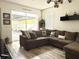 Comfortable living room featuring a large sectional sofa, neutral decor, and sliding glass doors to the patio at 14945 Huntcliff Park Way, Orlando, FL 32824
