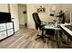 Well-lit home office featuring a comfortable chair, functional desk, and wood-look laminate flooring at 14945 Huntcliff Park Way, Orlando, FL 32824