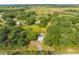 A lovely country home nestled within a canopy of trees, featuring a long private driveway and a storage shed at 150 N Post Office Rd, Kenansville, FL 34739