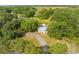 Property featuring a cozy home with an outbuilding surrounded by lush greenery and mature trees at 150 N Post Office Rd, Kenansville, FL 34739