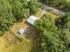 Aerial view of a home with an outbuilding surrounded by trees, showcasing its secluded setting at 150 N Post Office Rd, Kenansville, FL 34739