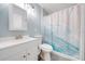 Bright bathroom with a new vanity, toilet, and walk-in shower with wave-patterned curtain at 150 N Post Office Rd, Kenansville, FL 34739