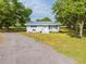 Charming exterior with updated paint, a gravel driveway, and mature trees at 150 N Post Office Rd, Kenansville, FL 34739
