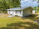 Charming exterior of a light blue home featuring window boxes, a walkway, and decorative shutters at 150 N Post Office Rd, Kenansville, FL 34739