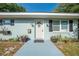 Close up of updated front door, decorative shutters, and new landscaping at 150 N Post Office Rd, Kenansville, FL 34739
