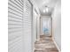 Hallway features stylish flooring, neutral walls, and closet with louvered doors at 150 N Post Office Rd, Kenansville, FL 34739