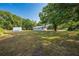 Quaint light blue house with a large yard and mature trees providing shade and privacy at 150 N Post Office Rd, Kenansville, FL 34739