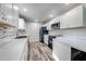 A modern kitchen with white cabinets, stainless steel appliances, and stylish tile backsplash at 150 N Post Office Rd, Kenansville, FL 34739