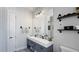 Modern bathroom with double vanity, a large mirror, and industrial style shelves at 1506 Euston Dr, Reunion, FL 34747