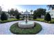 Beautiful community fountain in a circle of lush landscaping provides a welcoming outdoor space at 1506 Euston Dr, Reunion, FL 34747