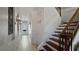 Hallway features tile floor, white walls, pantry, and wooden staircase with dark wood treads at 1506 Euston Dr, Reunion, FL 34747