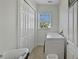 Laundry room with side-by-side washer and dryer, tile floors and bright window at 1506 Euston Dr, Reunion, FL 34747