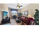 Bright living room with brown leather seating, desk, a view of the exterior, and a ceiling fan at 1506 Euston Dr, Reunion, FL 34747