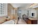 Spacious main bathroom with a soaking tub, large vanity, and walk-in shower, all with neutral tiling at 1506 Euston Dr, Reunion, FL 34747