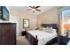 Inviting bedroom with a large dark wood bed, wood furniture, a ceiling fan, and bright windows at 1506 Euston Dr, Reunion, FL 34747