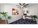 Staged office space, with a ceiling fan, large, colorful picture, and a black and white rug at 1506 Euston Dr, Reunion, FL 34747