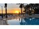 Resort-style swimming pool with lounge chairs and palm trees at sunset at 1506 Euston Dr, Reunion, FL 34747