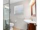 Clean bathroom with a tiled shower, cherry vanity with a vessel sink, and a window for natural light at 1510 E Ridgewood St, Orlando, FL 32803