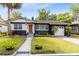 Charming blue home featuring a manicured lawn, blooming flowers, and a welcoming walkway at 1510 E Ridgewood St, Orlando, FL 32803