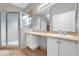 Bathroom with double vanity sinks, neutral tile, and walk-in shower with glass enclosure at 1532 Reade Cir, St Cloud, FL 34772