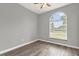 Cozy bedroom with hardwood floors and large window with view of the yard at 1532 Reade Cir, St Cloud, FL 34772