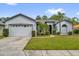 Charming single-story home with a well-maintained lawn, mature trees, and a two-car garage at 1532 Reade Cir, St Cloud, FL 34772