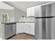 Modern kitchen with stainless steel appliances, white cabinets, and a view to a bright dining area at 1532 Reade Cir, St Cloud, FL 34772