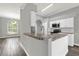 Modern kitchen featuring stone counters, white cabinets, stainless steel appliances and wood-style floors at 1532 Reade Cir, St Cloud, FL 34772