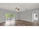 Bright living room featuring wood floors, neutral paint, ceiling fan, and access to screened porch at 1532 Reade Cir, St Cloud, FL 34772
