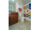 Bathroom with granite vanity, tiled floors, and a colorful shower curtain at 1599 Thetford Cir, Orlando, FL 32824