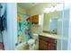 En-suite bathroom with a mermaid-themed shower curtain, granite countertop, and white fixtures at 1599 Thetford Cir, Orlando, FL 32824