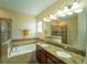 Bright bathroom featuring double sinks, granite countertops, and a separate tub and tiled shower at 1599 Thetford Cir, Orlando, FL 32824