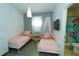 ' bedroom featuring two twin beds, a modern light fixture, and an ensuite bathroom at 1599 Thetford Cir, Orlando, FL 32824