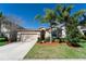 Exterior view of home showing the front yard, driveway, and attached garage at 1599 Thetford Cir, Orlando, FL 32824