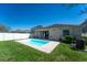 Backyard view of pool with surrounding grass and home exterior at 1599 Thetford Cir, Orlando, FL 32824