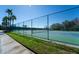 Well-maintained tennis courts surrounded by a tall green fence and greenery at 1599 Thetford Cir, Orlando, FL 32824