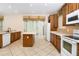 Bright kitchen with tile floors, wood cabinets, white appliances, island, and sliding glass door at 1607 Tail Feather Dr, Kissimmee, FL 34746