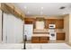 Traditional kitchen with tile floors, wood cabinets, white appliances and center island at 1607 Tail Feather Dr, Kissimmee, FL 34746